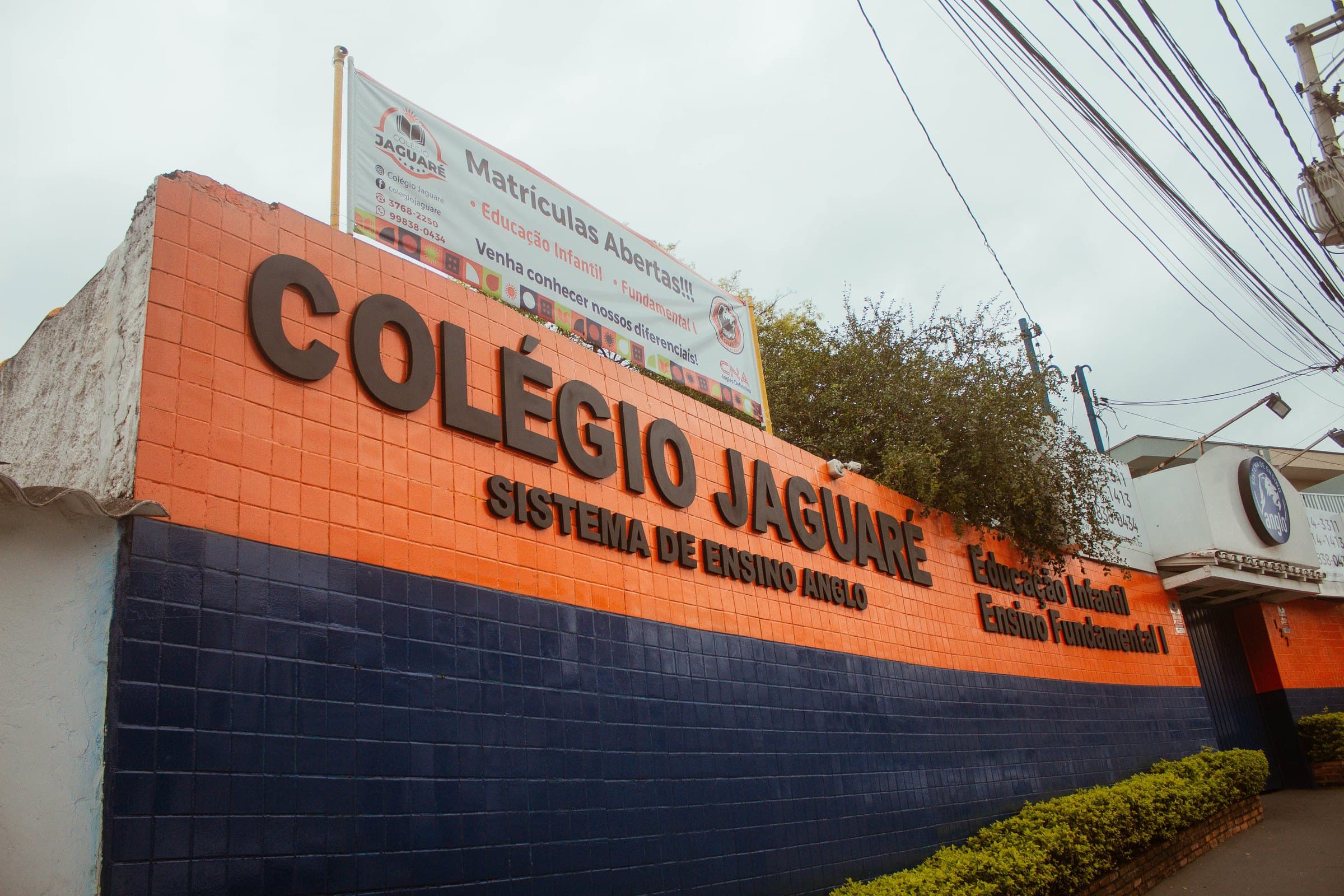 Fachada do Colégio Jaguaré, com o letreiro laranja e azul na Rua Irmã Pia