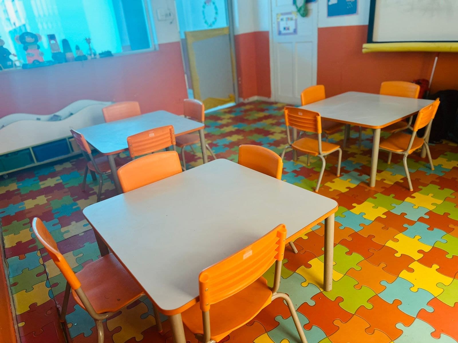 Mesas e cadeiras laranja em uma sala da Educação Infantil do Colégio Jaguaré